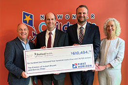 Patrick Miller and others holding a check. Links to The Estate of Hubert Bryant and Bonnie Miller story