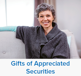 A woman smiling. Links to Gifts of Appreciated Securities
