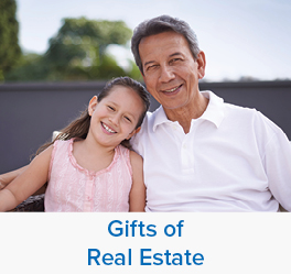 A girl smiling with her grandfather. Links to Gifts of Real Estate